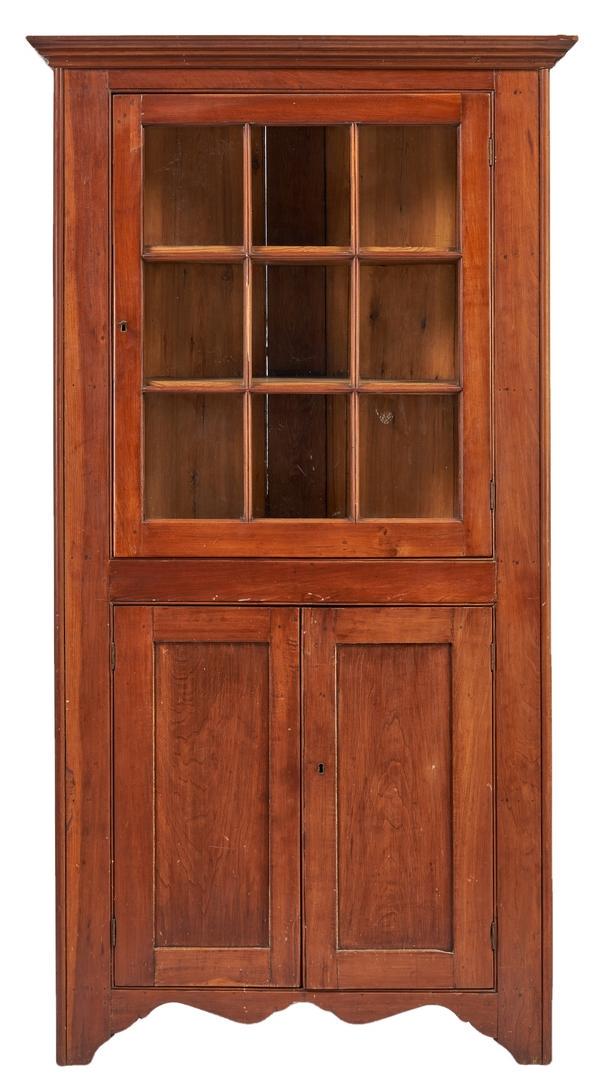 Southern Corner Cupboard w/ Bracket Base: Southern, possibly Virginia, one-piece cherry corner cupboard, yellow pine secondary wood. Top with an ogee cornice over one door having nine glass panes opening to reveal two interior shelves, base w