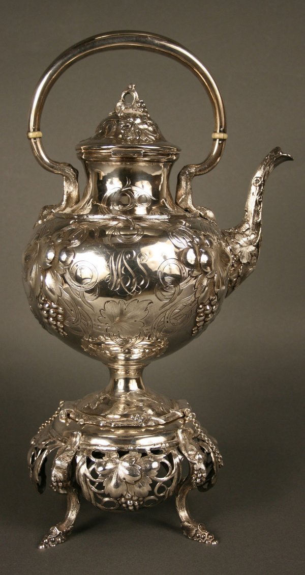American coin silver kettle on stand: American coin silver kettle on stand. Kettle with elaborate chased & embossed floral, scroll, & grape leaf design. Hinged lid with grape cluster finial, ivory ferrules. Front inscribed with crest, shi