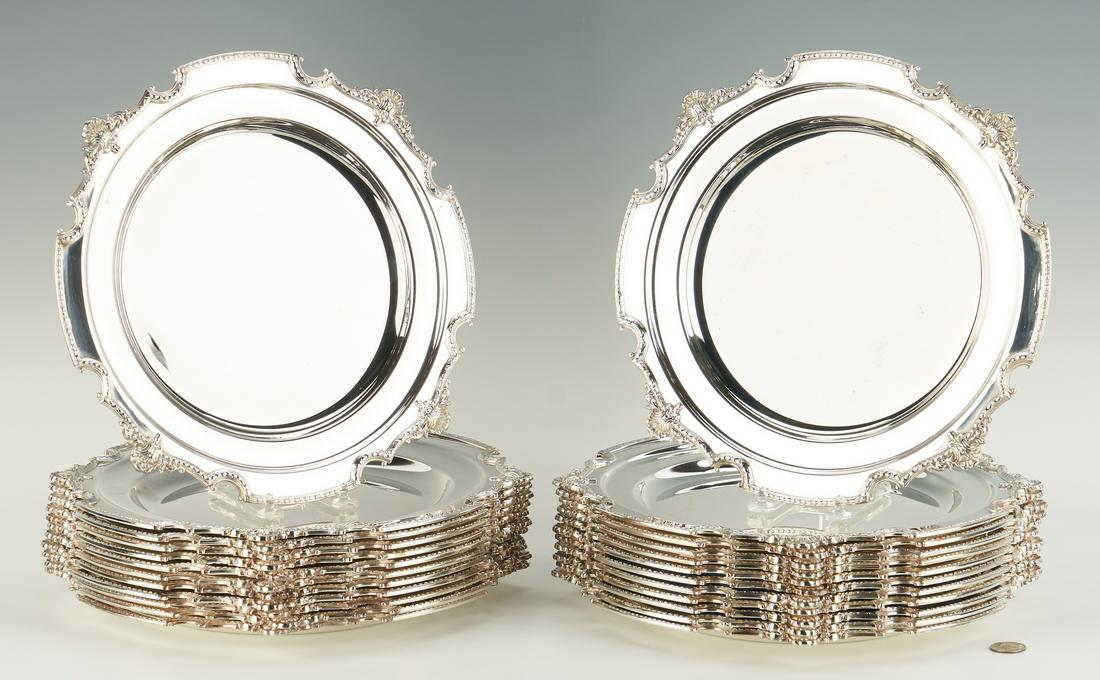 24 Silverplated English Chargers: Twenty four (24) silverplated chargers. Old tag accompanying the chargers states they are after a Rococo design by Paul de Lamerie (1688-1751). Deeply scalloped borders with rosette rims divided by fo