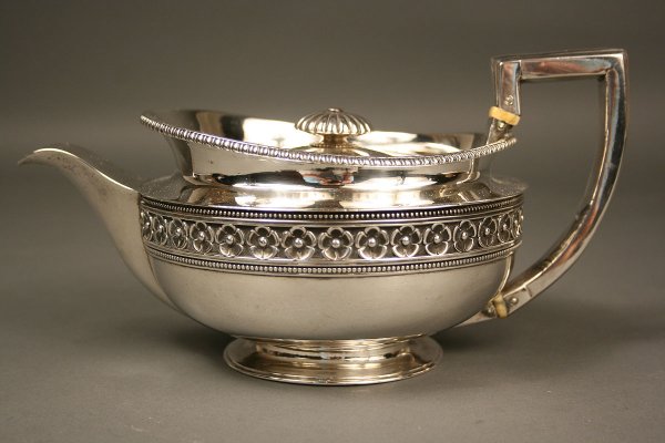 George III Sterling Silver Teapot: English sterling teapot, hallmarks for Benjamin and James Smith, London, 1810-1811. Overall very good condition with very slight pitting to bowl and handle. 4 3/4" Height x 9 1/2" Length x 5 1/2" Diam