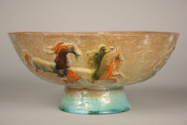 Wiener Werkstatte pottery: Wiener Werkstatte pottery pedestal bowl, blue/green and tan glaze with carved relief figures of horses and trees on exterior of bowl. Incised "Made in Austria" and "? Schleeberg" on bottom. Condition 