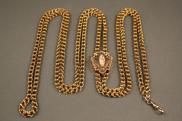 Woman's 14 K gold Victorian chatelaine: Woman's 14K gold Victorian chaitelaine comprised of a double inverted ring chain with a sliding enamel pendant. Pendant is hand painted and depicts young child with raised arms and is surrounded by el
