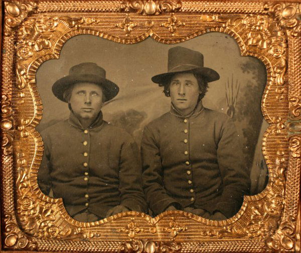 Civil War tintype, 2 Union Cavalry soldiers: Cased sixth-plate tintype of two Union Cavalry soldiers in enlisted shell jacket uniform. Front of case decorated with eagle, American flag, shield, fort, ship, sword, law book, and floral elements. C