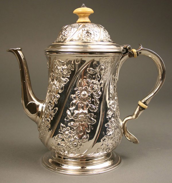 George II sterling silver pot, Isaac Cookson: George II sterling silver hot water pot, hinged lid having chased floral design and ivory finial, C form handle with ivory ferrules, slightly bulbous body with chased floral design in swirled panels o