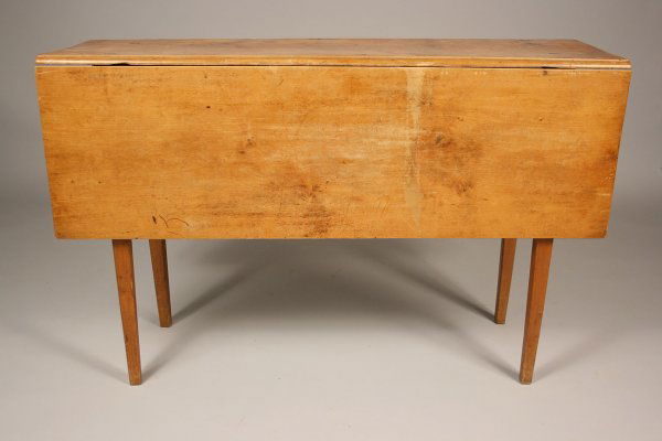 Diminutive maple drop leaf table: Diminutive and narrow maple drop leaf table, most likely New England, with tapered Hepplewhite legs and narrow, pegged central board top. Dovetailed apron where leg fold out for leaves. Overall expect