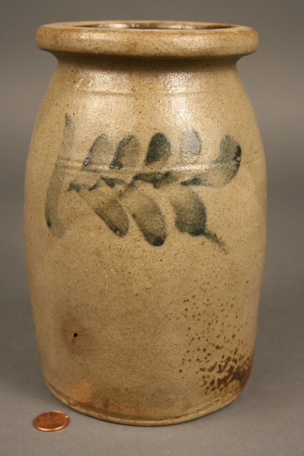 Southern, possibly Virginia stoneware jar: Salt-glazed stoneware jar with incised line decoration around upper mid-section and cobalt blue feather decoration on both sides. Condition - Old chip to base and some firing imperfections. 8 1/4" Hei