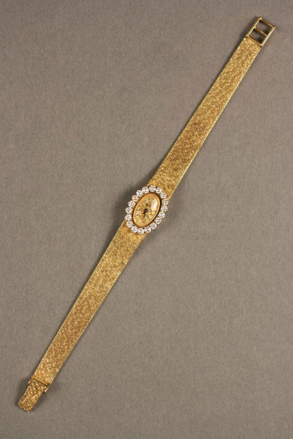 18K Gold and Diamond Watch, Girard Perregaux: Ladies Girard Perregaux 18K yellow gold watch featuring eighteen .06 carat mounted round full cut diamonds (1.08 total cts.). 7 1/4" length x 1/2" face width. 1.195 oz troy. Appraised value- $4350.00.
