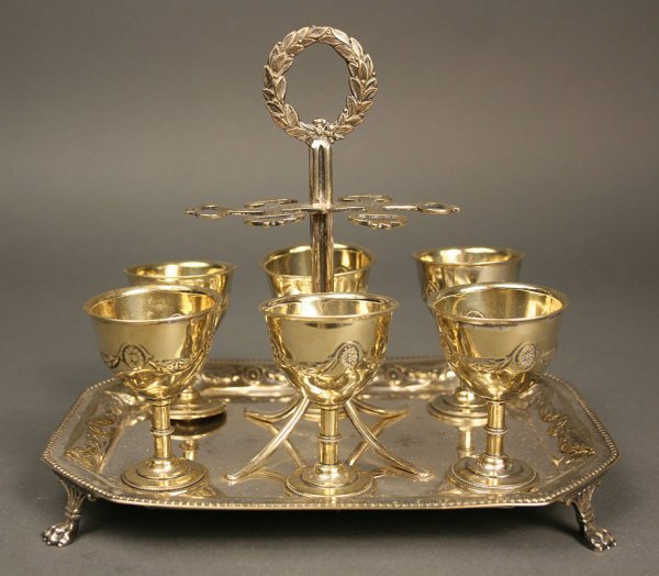 English silver egg cruet stand, Dixon & Sons: James Dixon and Sons English silverplated egg cruet or cordial set, six goblet form egg cups, gilt-washed interiors, on footed stand with chased laurel and swag design handle and rims. Missing spoons.