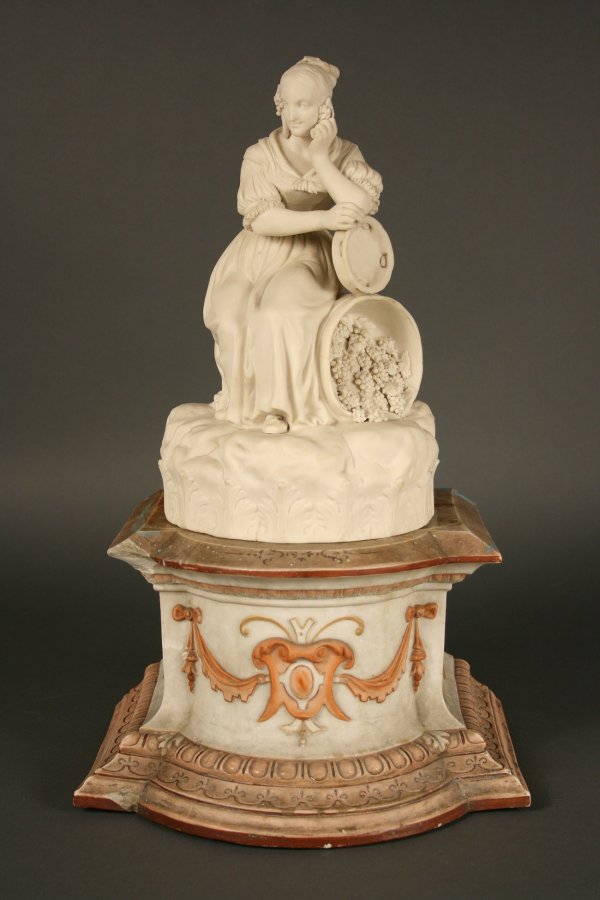 Copeland Parian figure: Copeland Parian figure of maiden holding tambourine seated on keg of grapes resting on a classical base. Impressed "Copeland" on backside of base. Overall good condition with some breaks to grape leav