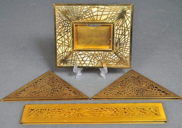 Tiffany Studios bronze desk items: Grouping of four Tiffany Studios bronze desk items. 1st item - bronze and slag glass picture frame (940). Marked Tiffany Studios. Condition - several cracks to slag glass in reverse with overall surfa