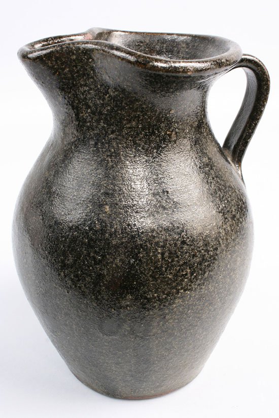 NC Alkaline glaze pitcher: Buncombe County, North Carolina pottery Pitcher in dark green to black alkaline glaze with white specs. Unmarked. Very good condition with minor rim exfoliation to glaze. Measures 8 1/2" Height. Prove