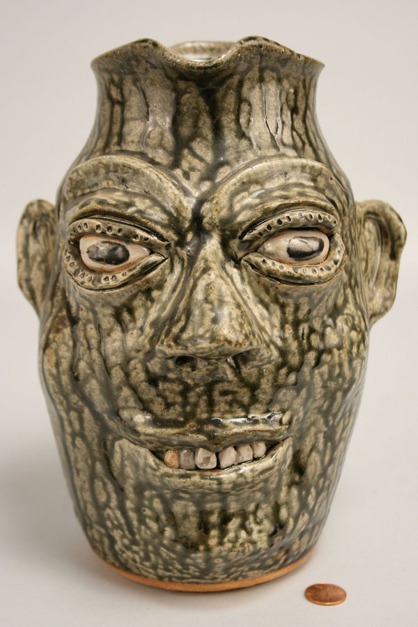Meaders Face Pitcher, Cleater and Biller Meaders: Meaders face pitcher, Cleater and Billie Meaders, with ceramic teeth and eyes, olive glaze drip, marked on base "Cleater and Billie Meaders, 1990". Excellent condition. Measures 9 7/8" H. Provenance: 
