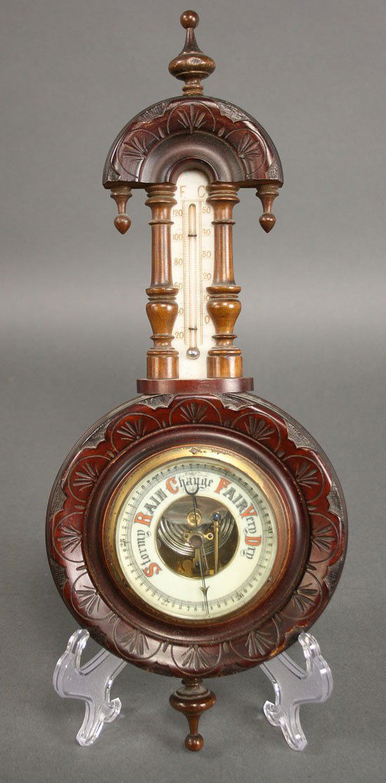 Victorian aneroid barometer thermometer: Victorian Aneroid barometer, carved mahogany case with porcelain enameled thermometer and barometer dials. Oxidation to brass surrounding barometer dial, slight edge wear to case and finial, not teste
