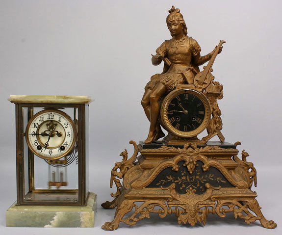 French Mantel Clock and New Haven Clock: Lot of 2 clocks. 1st item - French mantel clock mounted in a footed gilded white metal case, enhanced with two marble panels and cast figure of musician cresting the case. Black face with Roman numera