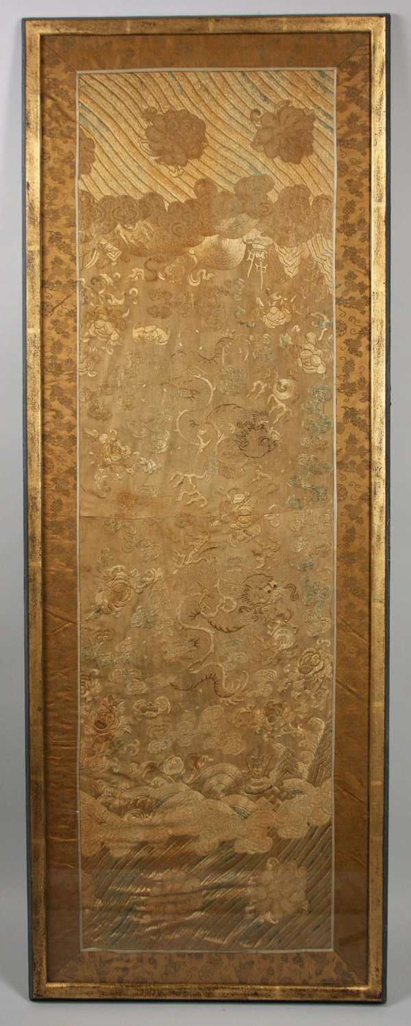 Asian embroidered silk panel, framed: Oriental silk panel, embroidered in silk threads with dragons and storm clouds in shades of taupe, beige and blue, with brown silk floral border. Center seam. In a contemporary gilt wood frame with bl