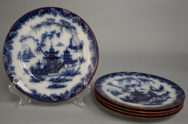 Set of 5 Whampoa flow blue ironstone plates: Set of five (5) Whampoa flow blue ironstone plates, each depicting an Oriental scene with red borders and gilt highlights. Three plates stamped "IMPROVED STONE" on back with "WHAMPOA" mark. Two plates