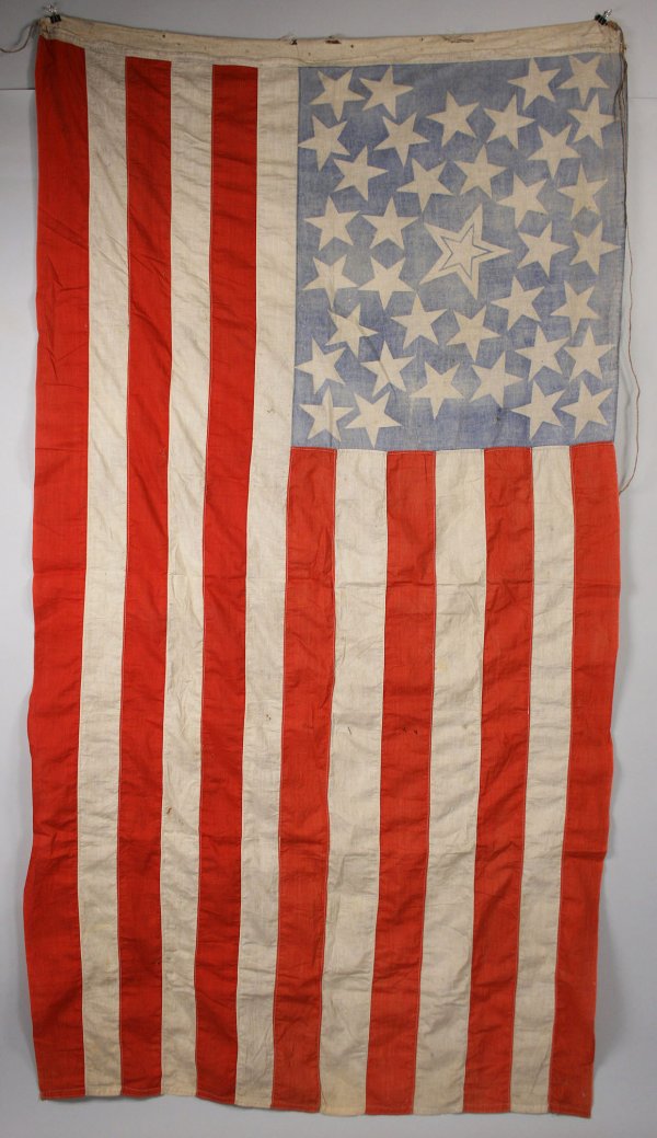 38 star United States American Flag: Hand sewn thirty-eight (38) star cotton United States American flag with thirty-seven stars arranged around one larger central white star with inclined blue star and six white and seven red stripes. O