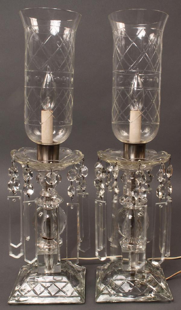 Pair of crystal lustre lamps: Pair of crystal lustre electric lamps with diamond cut hurricane shades. Good condition with one prism missing and scattered chips to some other prisms. 21 1/2" H x 6" square base. Early 20th century.