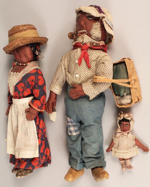 Folk Art African American Doll Family: Folk Art Doll Family, hand-sewn cotton black male, female and child dolls, each with bead eyes. Male doll carries a straw market basket, smokes a corncob pipe and wears leather sewn shoes. Female doll