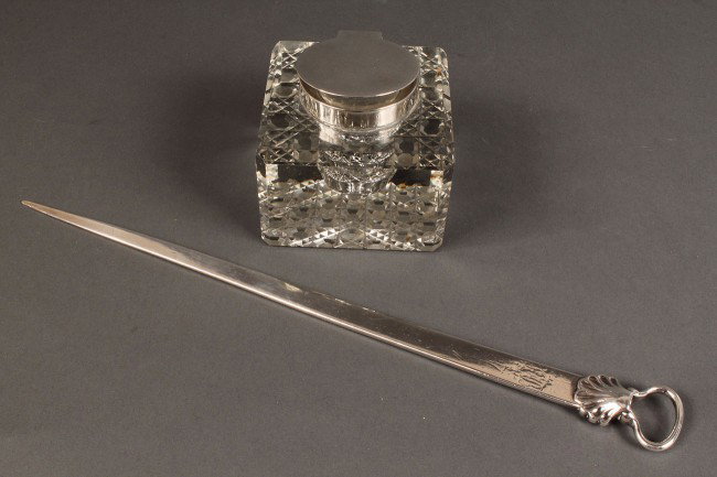 Lot of 2 Desk Items, Page Ripper & Inkwell: Lot of two desk items. 1ST ITEM: A sterling silver "page ripper" or "page turner" used to rip the fresh pages of a new book, with molded shell and loop handle, marks for London, 1843, W.P. maker's mar