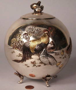 Japanese Mixed Metals Silver urn: Japanese silver urn or tea caddy, globular form raised on four leaf-form feet, decorated with applied rooster and hens in various colors of gold plate. Removable insert. Lift top lid features figural