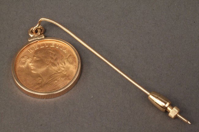 Gold 1935 Helvetia 20 Franc Coin Stick Pin or Pend: 1935 Helvetia 20 Franc Framed Bouillon Coin Stick Pin in a 14K marked yellow gold mounting. 9.4 grams total weight, coin 6.4 grams of 22K gold. Provenance: Knoxville, TN collection.