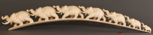 Asian carved tusk of Elephant parade: Asian Carved tusk depicting a line of Walking Elephants in graduated in size, small to large, mounted on a custom black wooden carved base, excellent condition, tusk: 19" L x 2-1/8" W x 2-1/4" H, base