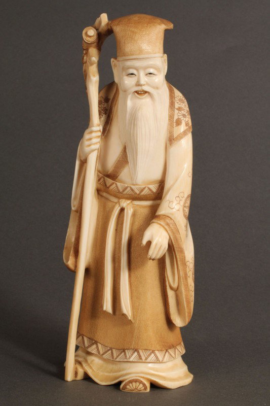 Asian Ivory figure, Scholar holding staff: Asian Carved Ivory Scholar, smiling and holding staff with red seal mark on base. Good condition with crack down left front of robe and alongside beard. 7-1/2" H x 2-3/4" W x 2-1/8" D, early 20th cent