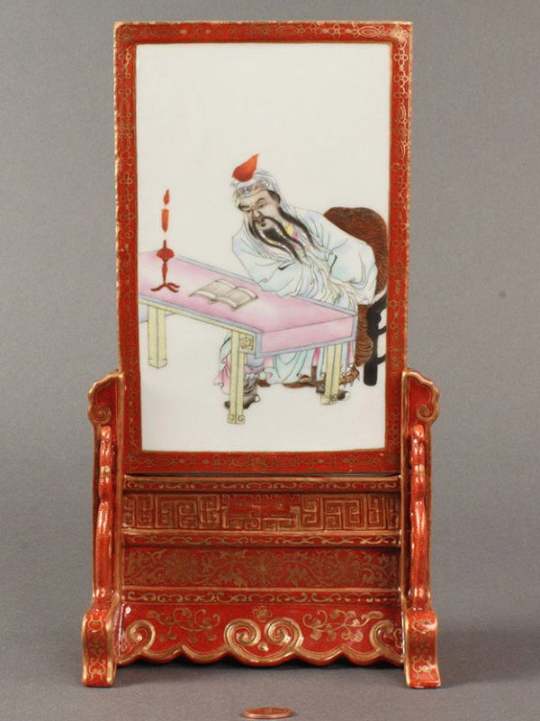 Small Chinese Famille Rose table screen: Small two-sided Famille Rose porcelain panel table screen depicting man reading book at table on one side, with bird of prey perched above the ocean on the other. Mounted in a red painted porcelain st