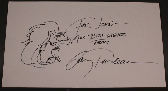 Gary Trudeau cartoon and autograph: Drawing of a Doonesbury character, signed by cartoonist Gary Trudeau in black ink, "For John - All Best Wishes From Gary Trudeau". Overall excellent condition. 8-3/4" W x 5" H.