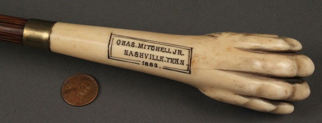Umbrella with Ivory and rosewood handle: Umbrella with Ivory and rosewood handle, the ivory carved in a ball and claw design and engraved: "Chas. Mitchell Jr. Nashville Tenn. 1883". 39 1/2"L. Condition: claw missing two talons, with crack ne