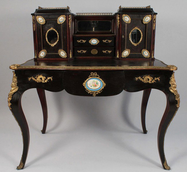 Napoleon III Mahogany & Ormolu Lady's Writing Desk: A Napoleon III ebonized mahogany and gilt bronze-mounted ladies desk, with two letter cabinets flanking a pair of drawers, inset shaped leather writing surface, serpentine top over a shaped apron with