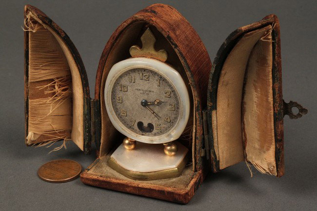 Miniature Swiss travel clock c.1900: A miniature Swiss travel clock, gilt brass or bronze and mother-of-pearl case stamped "Lenox W. Co" Swiss, engine turned dial labeled Fleur de Lys de Paris. Contained in original wood case with remnan