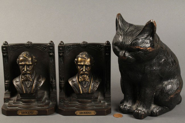 Bronze bookends and cat doorstop: 1ST ITEM: Bradley & Hubbard bronze bookends, labeled busts of Charles Dickens, marked B&H on back. Busts slightly loose with some wear, overall very good condition, 5 1/2"H. 2ND ITEM: Sitting cat door
