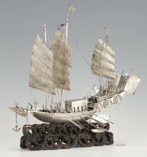 Large Chinese Export Silver Model of a Ship and Rowboat, Carved Stand Simulating Waves: Large Chinese export silver model of a ship or junk, outfitted with sails, oars, figures, cannons, anchors, and pikes, together with a smaller manned rowboat, both fixed to a carved hardwood stand