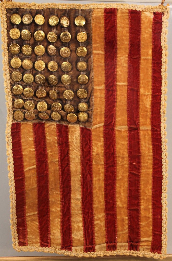Display flag with state button stars: Small display silk velvet flag with 48 state seal buttons forming the stars. Edged in silk tassel fringe. The date of each state's admission is handwritten en verso. Housed in a custom acrylic case wi