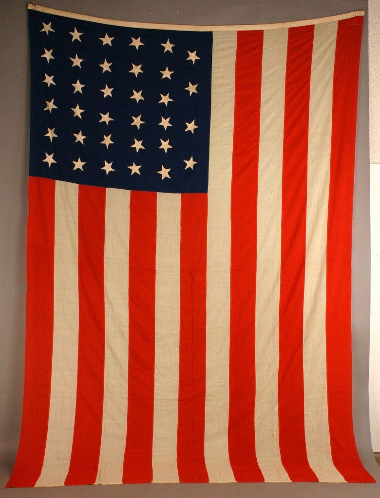 34 star American flag: 34 star American National Flag, cotton with whipped eyelet grommets and machine stitched stripes, hand-sewn cutaway stars on back. Dated 1860. Approximate size: 92"H x 136"W. Possibly Civil War era. P