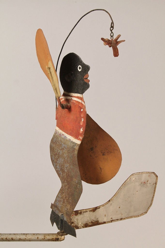 Folk Art Whirligig, African American figure: Painted sheet tin whirligig, African American figure with rotating fan arms, painted in striped pants and red coat staring at a bird. Displayed on contemporary metal stand. 32 1/4" H x 13" W x 8 3/4"