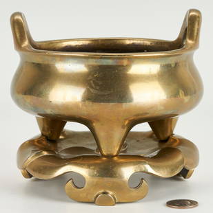 Chinese Gilt Bronze Censer & Stand, Ming Style: Chinese gilt bronze tripodal censer or incense burner, low round form with twin handles, resting on a gilt bronze wave design tripodal stand. Underside of censer with likely apocryphal six character X