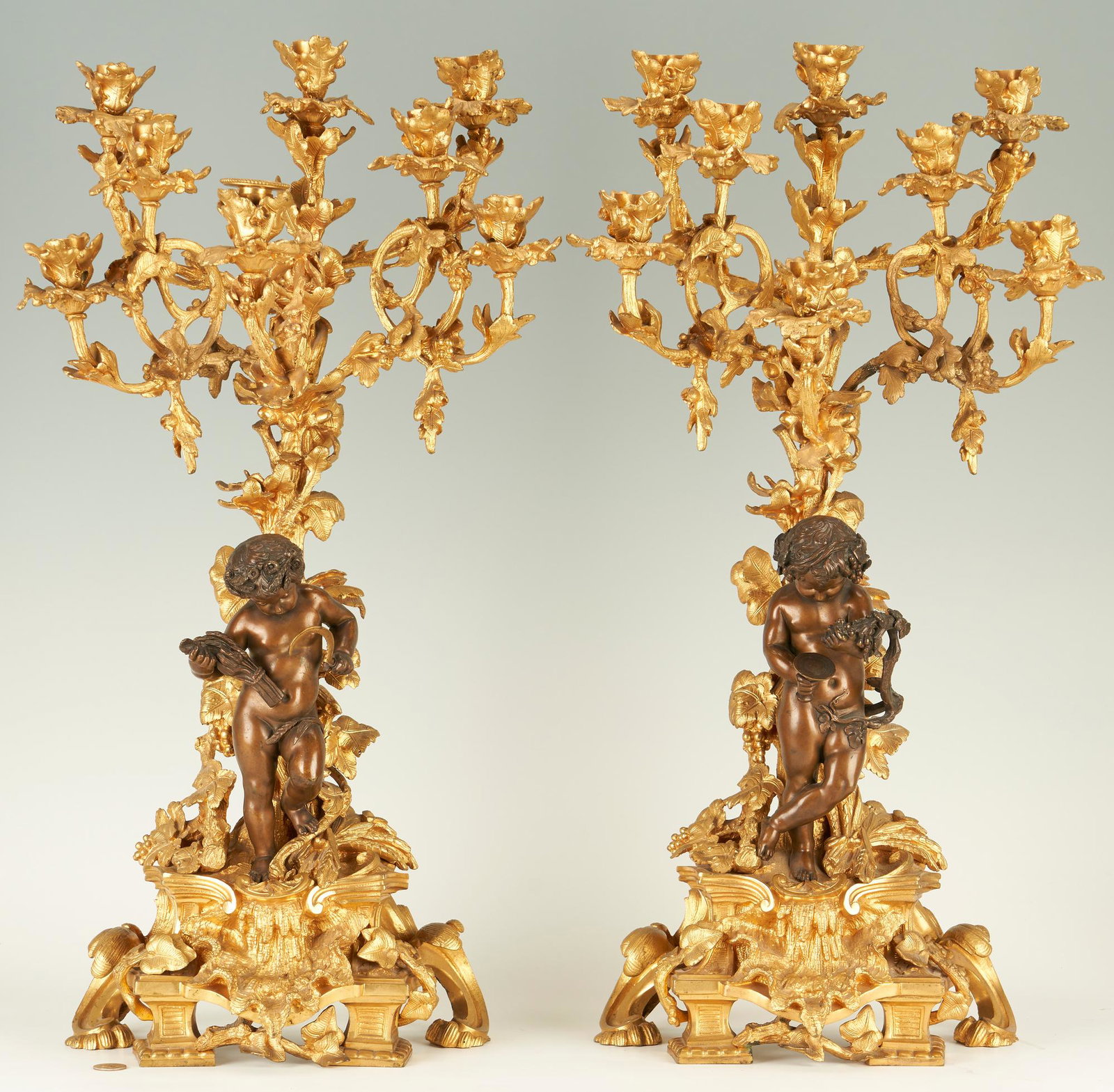 Pr. of Louis XV Style Dore Bronze and Patinated Candelabras: Pair of two (2) large French Louis XV style patinated dore bronze candelabras, each candelabrum having eight (8) arms that resemble intertwining grape vines, festooned with leaves and grape clusters, 