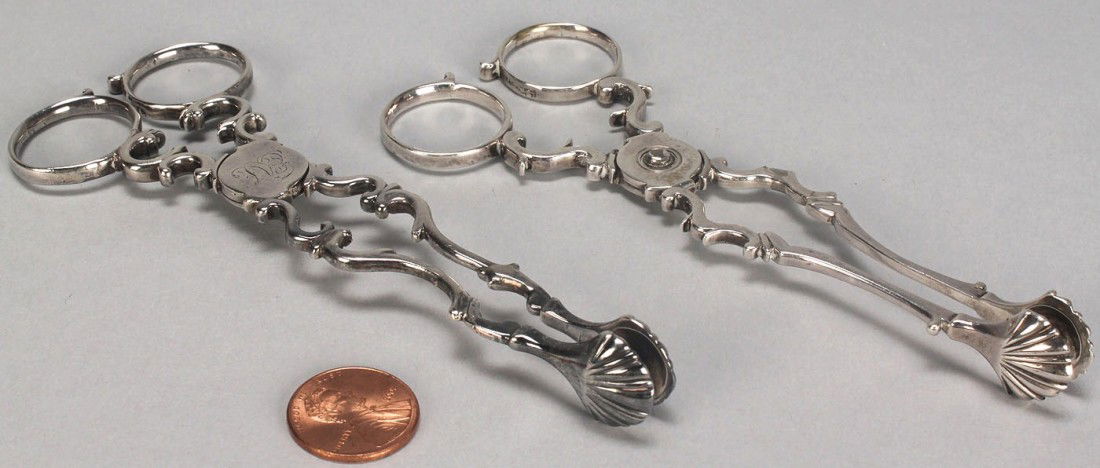 Two pairs George III silver sugar nips: Two Pairs of sterling silver sugar nips, both with scrolled scissor style handles and shell form grips, the first pair marked with lion passant and I C (attributed to John Carter II, working London la