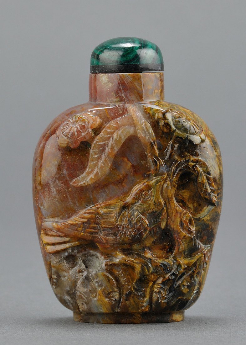 Chinese Carved Petersite Agate Snuff Bottle: Chinese carved petersite agate snuff bottle with carved bird amongst a flowering vine. 2 3/4" H. 20th century. Provenance: From the collection of the late Fred C. Kennedy, a renowned mineral collector