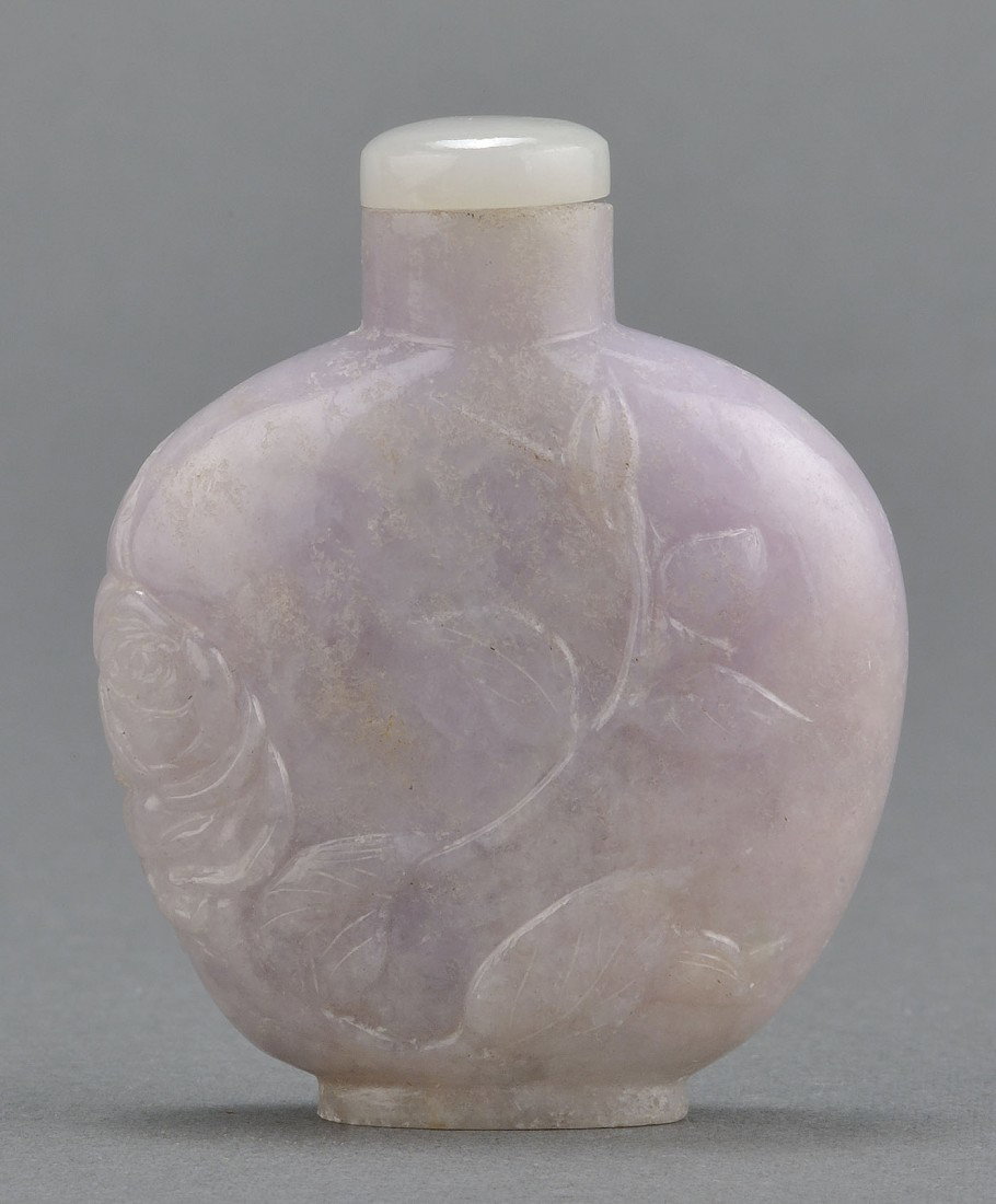 Chinese Carved Lavender Jade Snuff Bottle: Chinese carved lavender jade snuff bottle with relief floral decoration, en suite with lid. 2 3/8" H. 20th century. Provenance: From the collection of the late Fred C. Kennedy, a renowned mineral coll