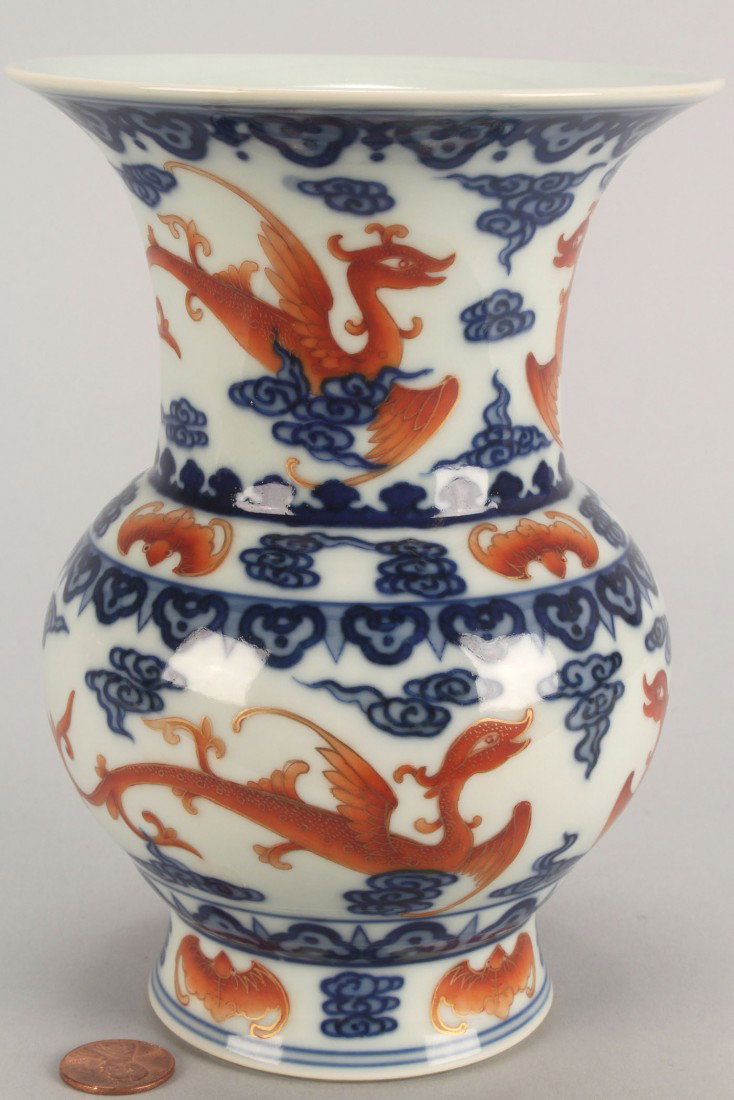 Chinese Porcelain Vase: Chinese porcelain vase, beaker form, with iron red dragon, bat, the knot and musical knot decoration and blue fungus decoration. Blue seal character mark on base. 6 3/8" H. 20th century.