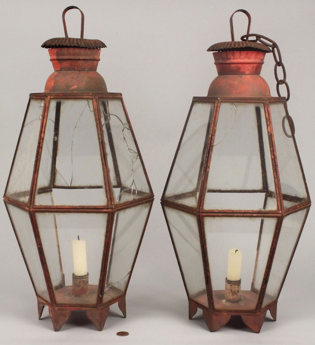 Pair of Red painted tin lanterns: Pair of tin lanterns in original red paint, hexagonal with bracket footed bases, candle cups, and crimped vented chimneys. 20"H. American, 19th century. Provenance: Estate of Salli LaGrone, Franklin,