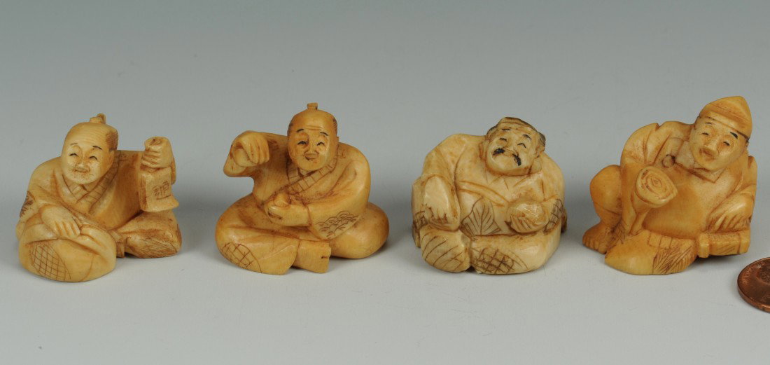 Group of Four stained ivory netsukes: Four stained and engraved ivory netsukes in the form of men holding various objects or tools, one signed on base. All approximately 1"H. Chinese or Japanese, early 20th c.