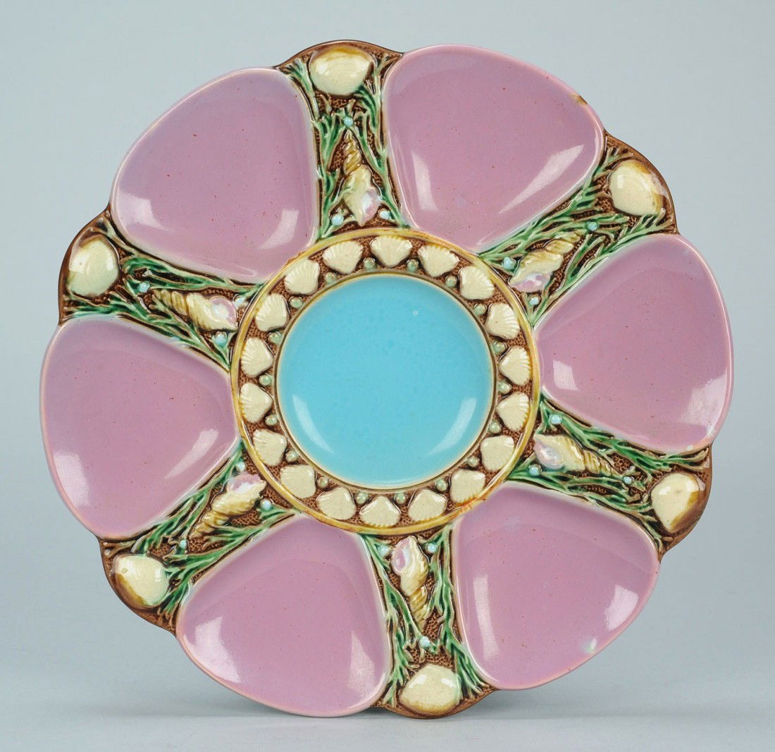 Minton pink Majolica oyster plate: Minton Majolica oyster plate with turquoise center well and pink side wells, all surrounded by seashell designs. Mintons mark, the shape number (1323) and English registry mark impressed on back (date