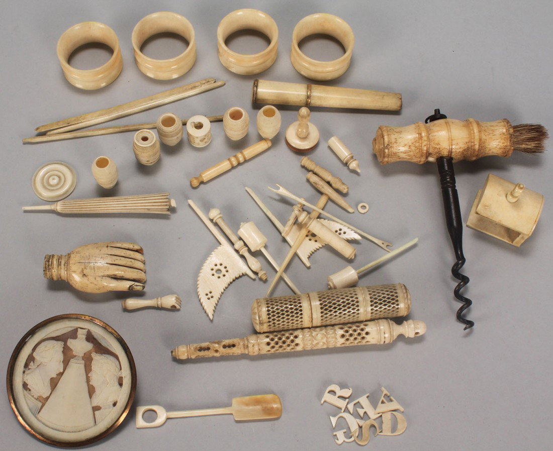 Assorted small ivory and bone antiques: Approximately 44 pieces of assorted bone and ivory. Includes: 1 bone handle corkscrew, 4 ivory napkin rings, 2 pierced ivory needlecases (1 is a Stanhope viewer showing images of the Palais du Trocade