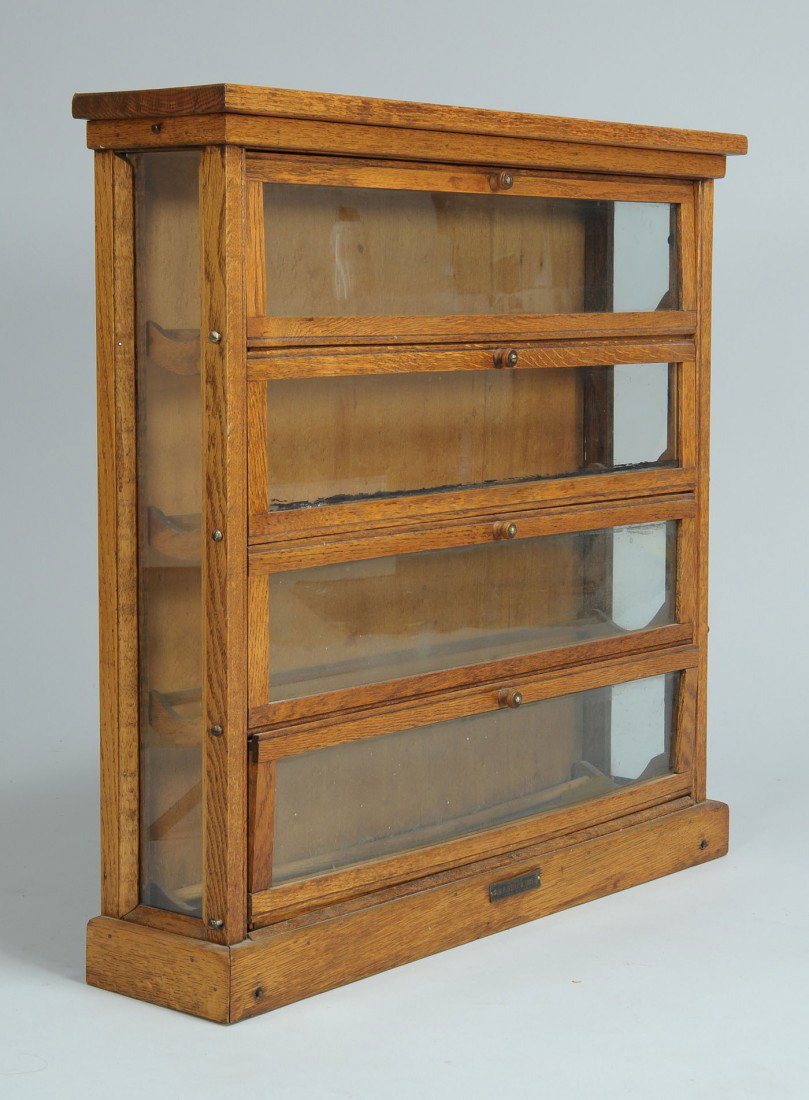 Country store oak counter top ribbon cabinet: Country store oak counter-top ribbon cabinet labeled A. N. Russell and Son Company, Ilion NY USA. Four bottom-hinged doors with interior ribbon racks and glass sides. 27 1/4" H x 27 1/4" W x 6 1/4" D.