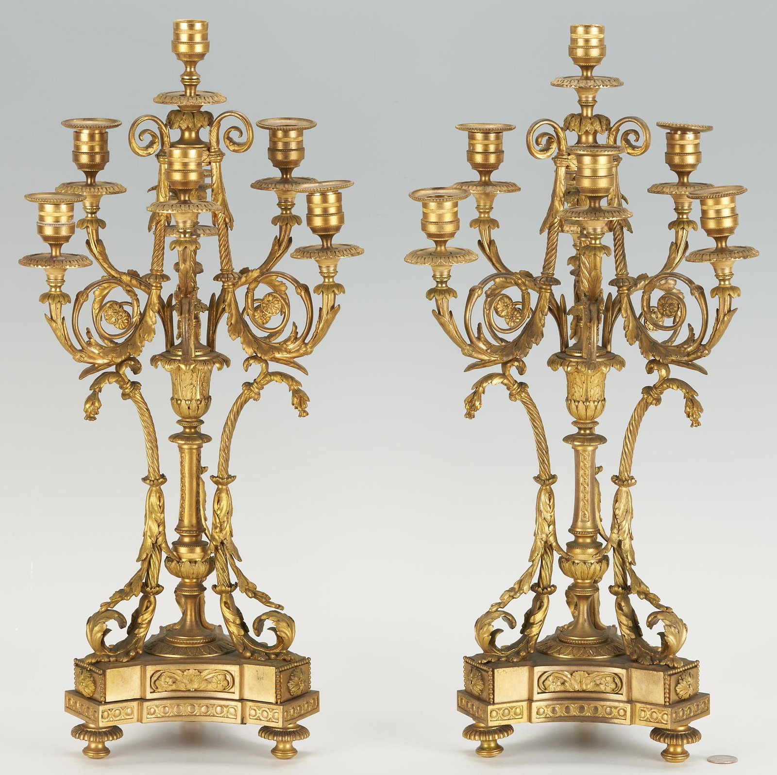 Napoleon III Bronze Candelabras, after Alfred Beurdeley: Pair of Napoleon III gilt bronze seven light candelabras in the manner of Alfred Emmanuel Louis Beurdeley (1818-1895.) The candelabras rest on a footed tripartite base and are adorned with finely cast